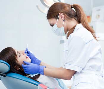 Young female dentist working in her office